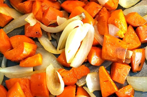 Cooked sweet potatoes, onion and garlic on a sheet pan.